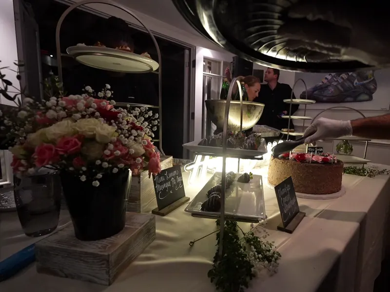 Dessert station with fresh florals and chalkboard signs at a country event