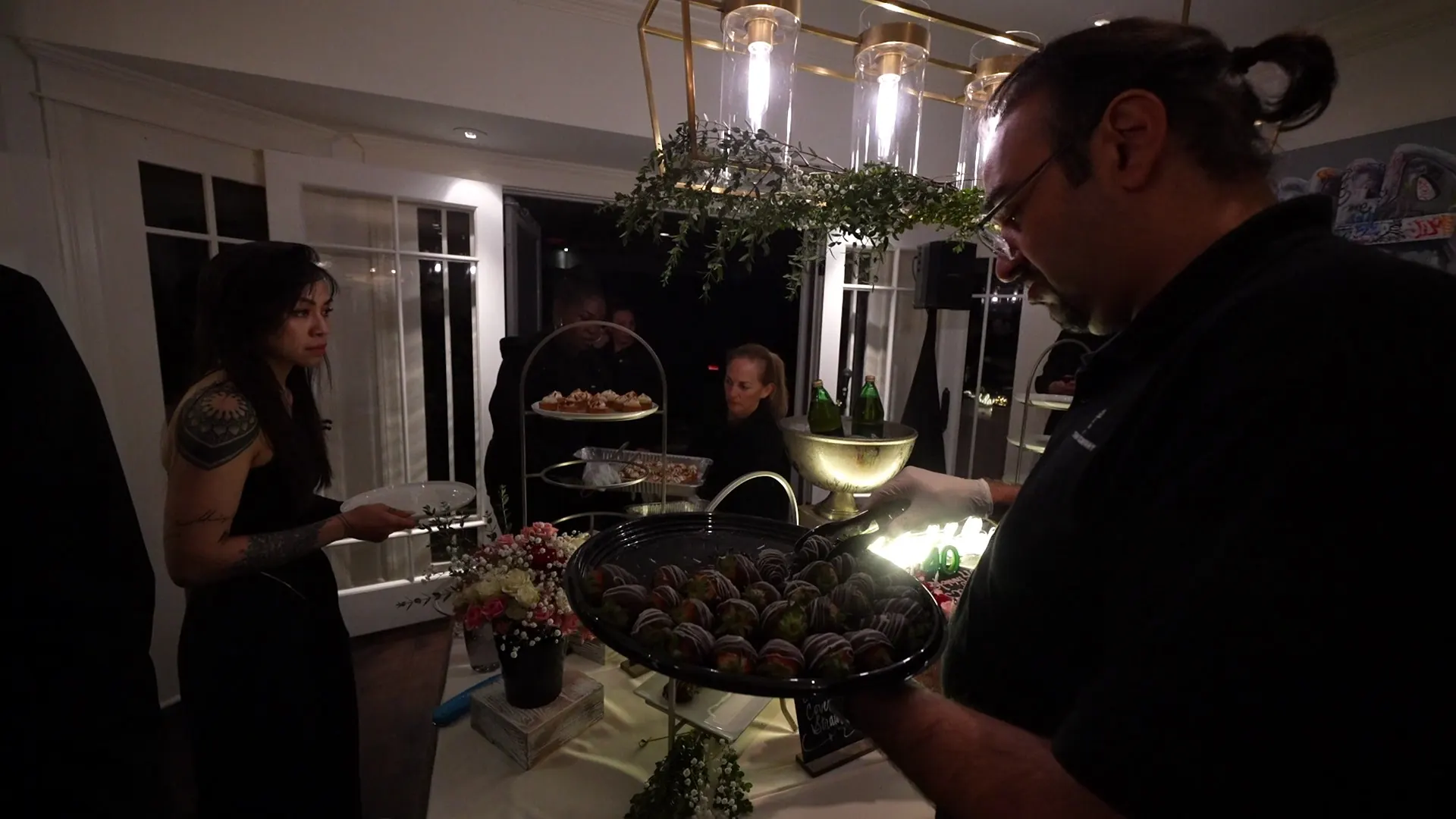 Catering staff plating desserts under pendant lights at a San Ramon event