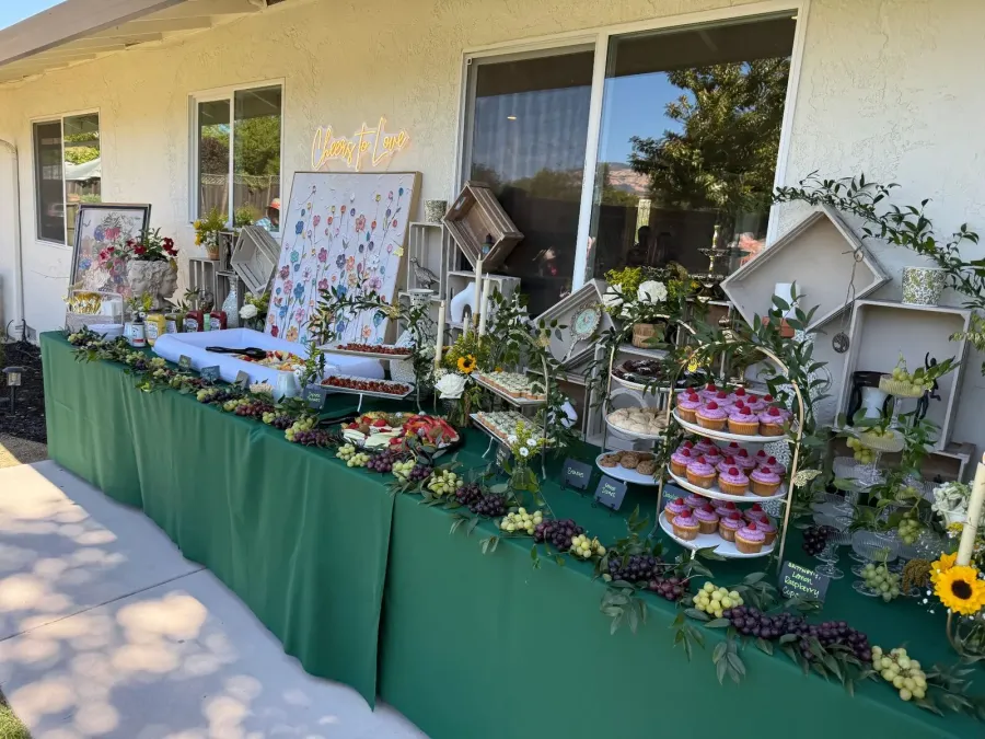Shower sweets table where cupcakes, grapes and berries sit among fresh stems and layered neutral linens — shower florals for San Ramon catering