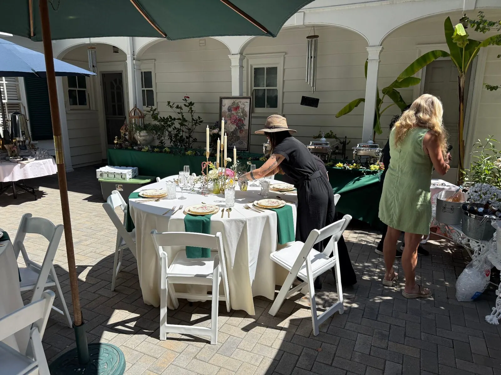 Courtyard tables in emerald linens with glassware, place settings and coordinated floral accents — rentals and floral styling for Tri-Valley catering