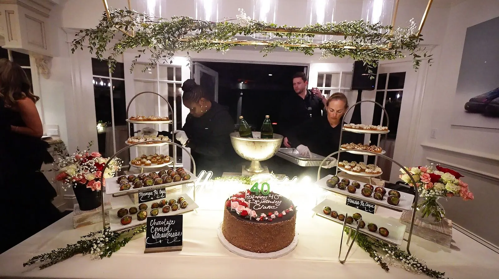Dessert station of dipped strawberries, celebration cake and petite sweets softened by small bud vases — dessert florals for Dublin celebrations
