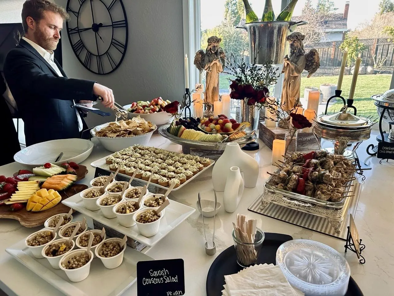 Crisp white-linen appetizer buffet with couscous salad, a sliced fruit platter and grilled skewers laid in neat rows — corporate catering for Dublin business parks