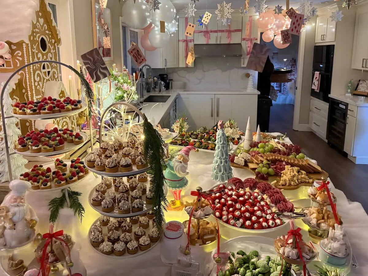 Themed party tablescape of tiered tarts, cupcakes and charcuterie finished with soft blooms and pastel balloons — floral event styling in Dublin