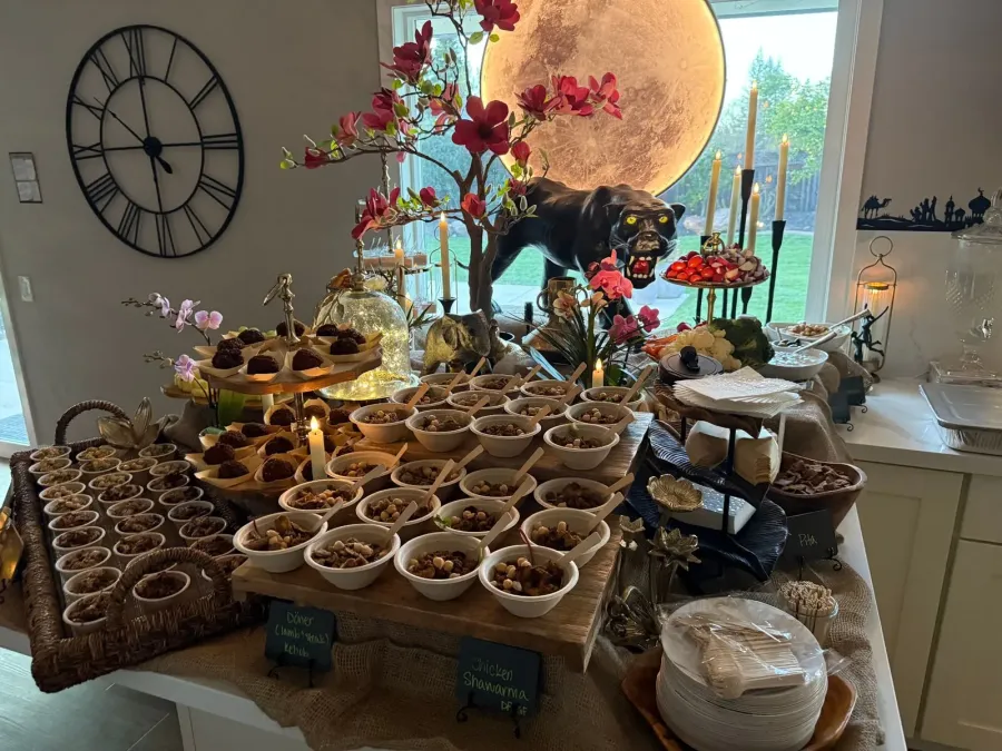Mediterranean buffet of shawarma, kebob and mezze framed by warm-toned arrangements and matching linens — floral pairing on Pleasanton catering menus
